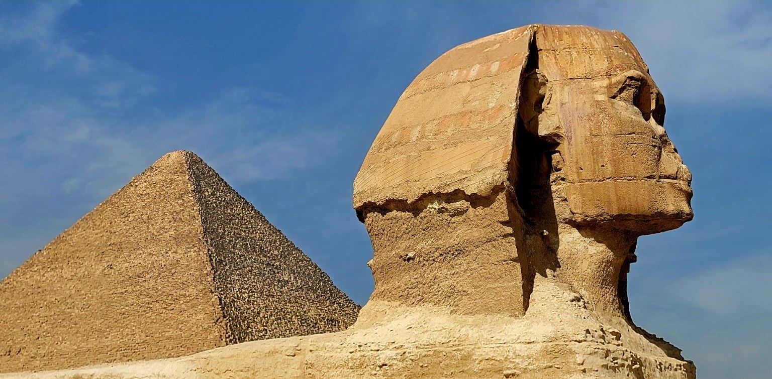 The Great Sphinx of Giza in profile with the Pyramid of Khafre rising behind