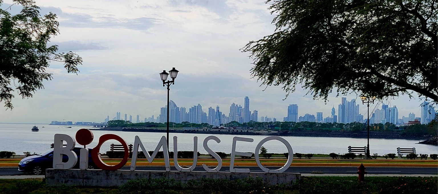 Biomuseo sign in the foreground with Panama City's modern skyline across the bay