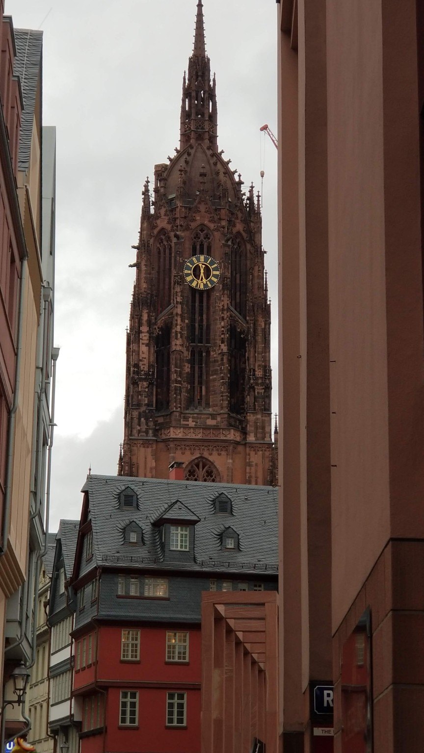 The tower of Frankfurt Cathedral framed by the dense streets of the old city
