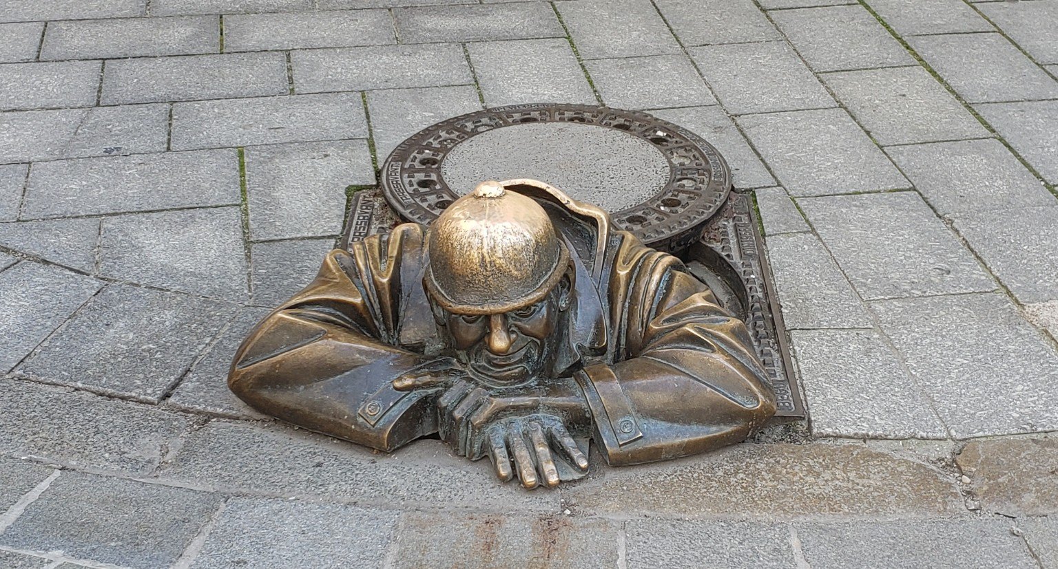 Cumil, the bronze man-at-work statue peeking out of a manhole in Bratislava