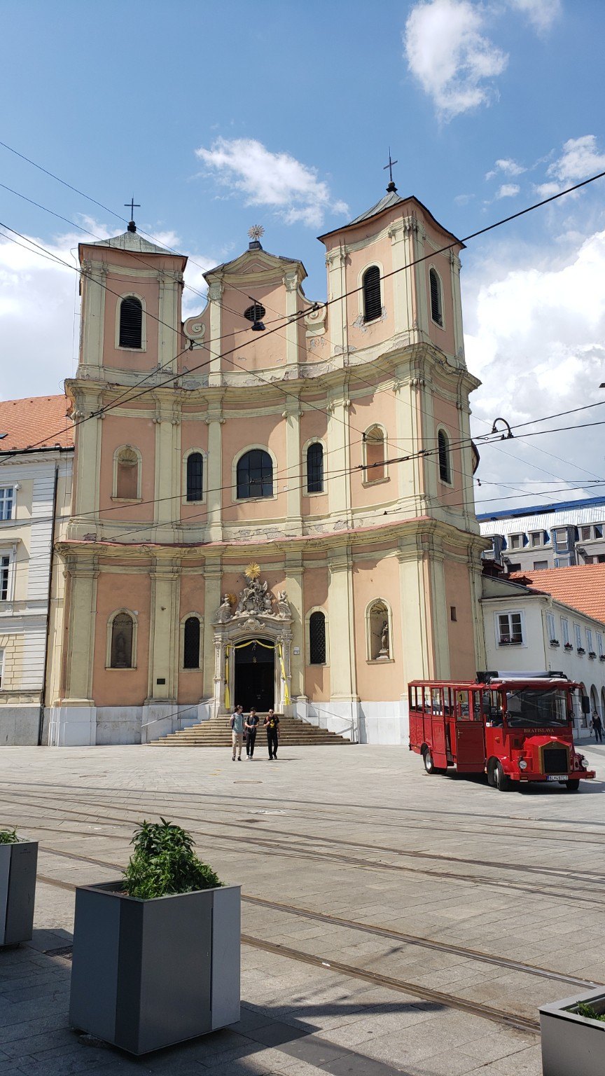 Pastel church facade with tram lines crossing in front