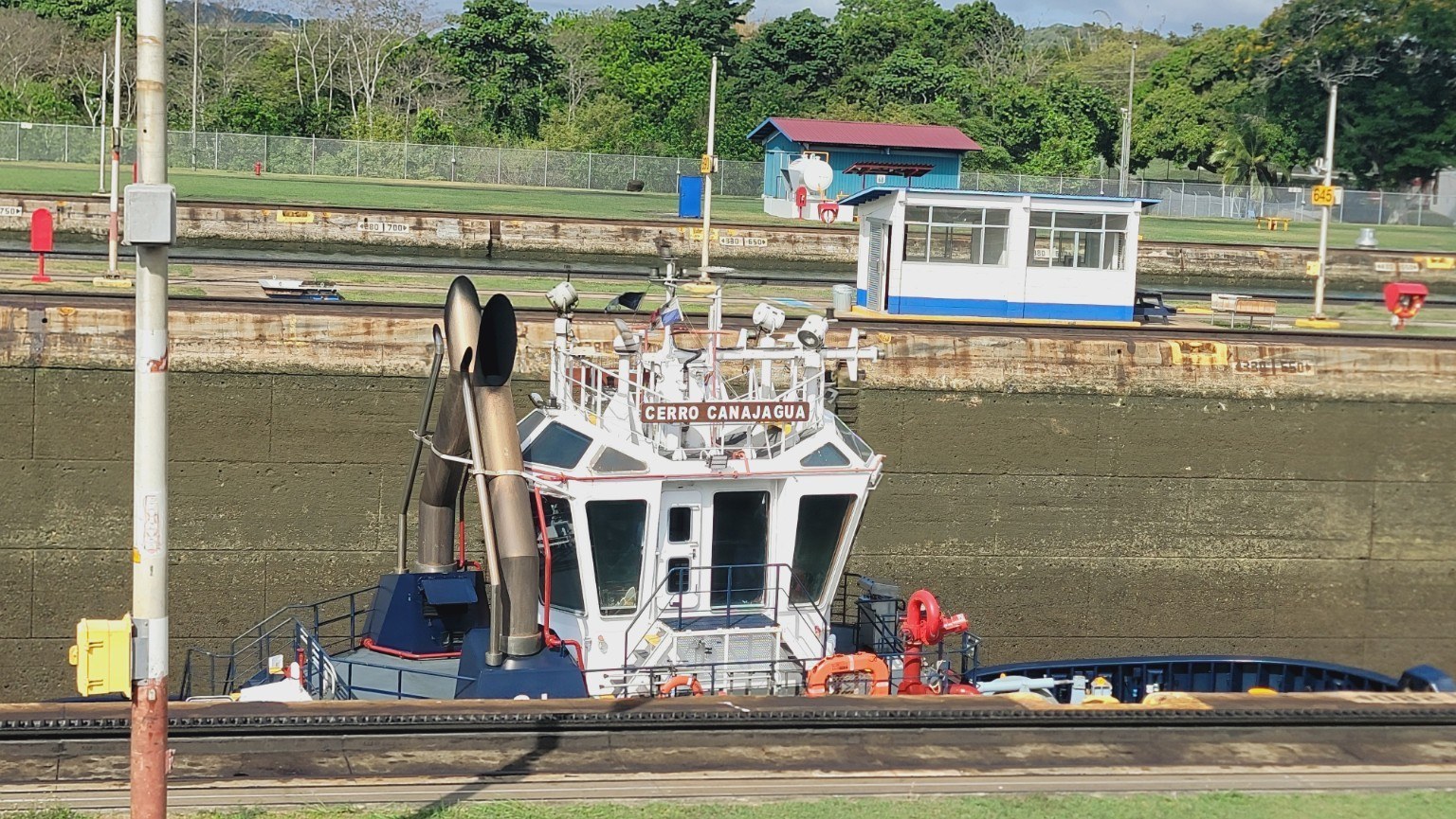 Panama Canal Authority tugboat 'Cerro Canajagua' alongside a ship in the lock