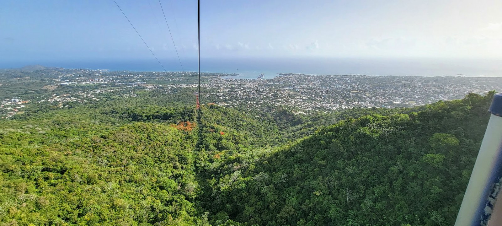 A hazy overlook from Mount Isabel de Torres, where rainforest falls into city and city falls into sea.