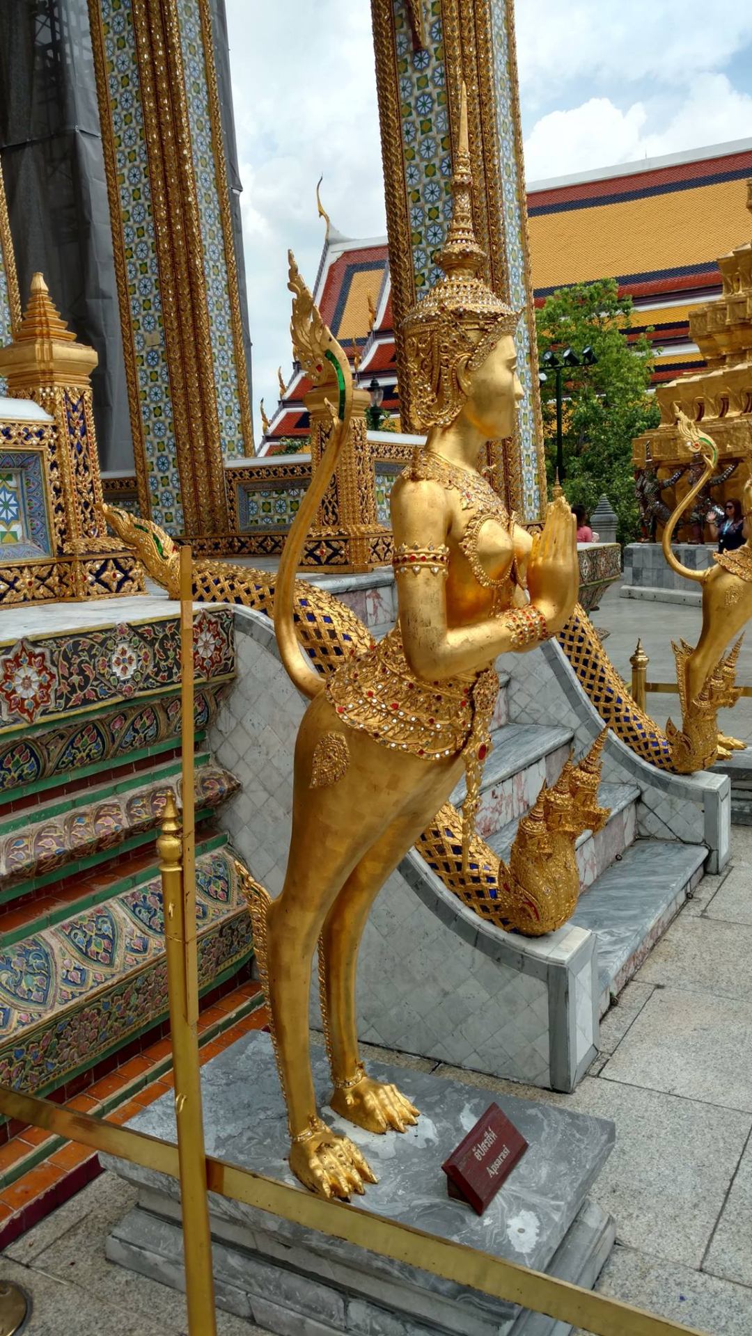 Golden Kinnari, a half-bird half-woman figure, standing as a guardian at the Grand Palace