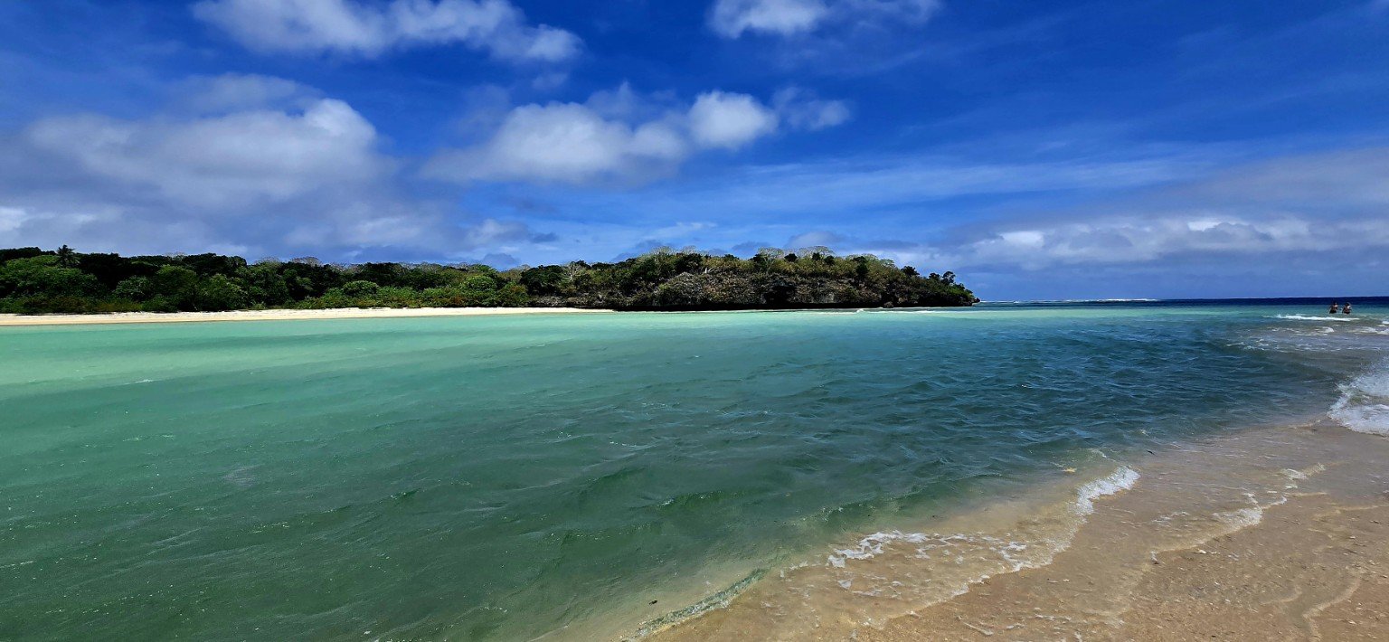 Shallow turquoise reef water and white sand on a Fiji beach