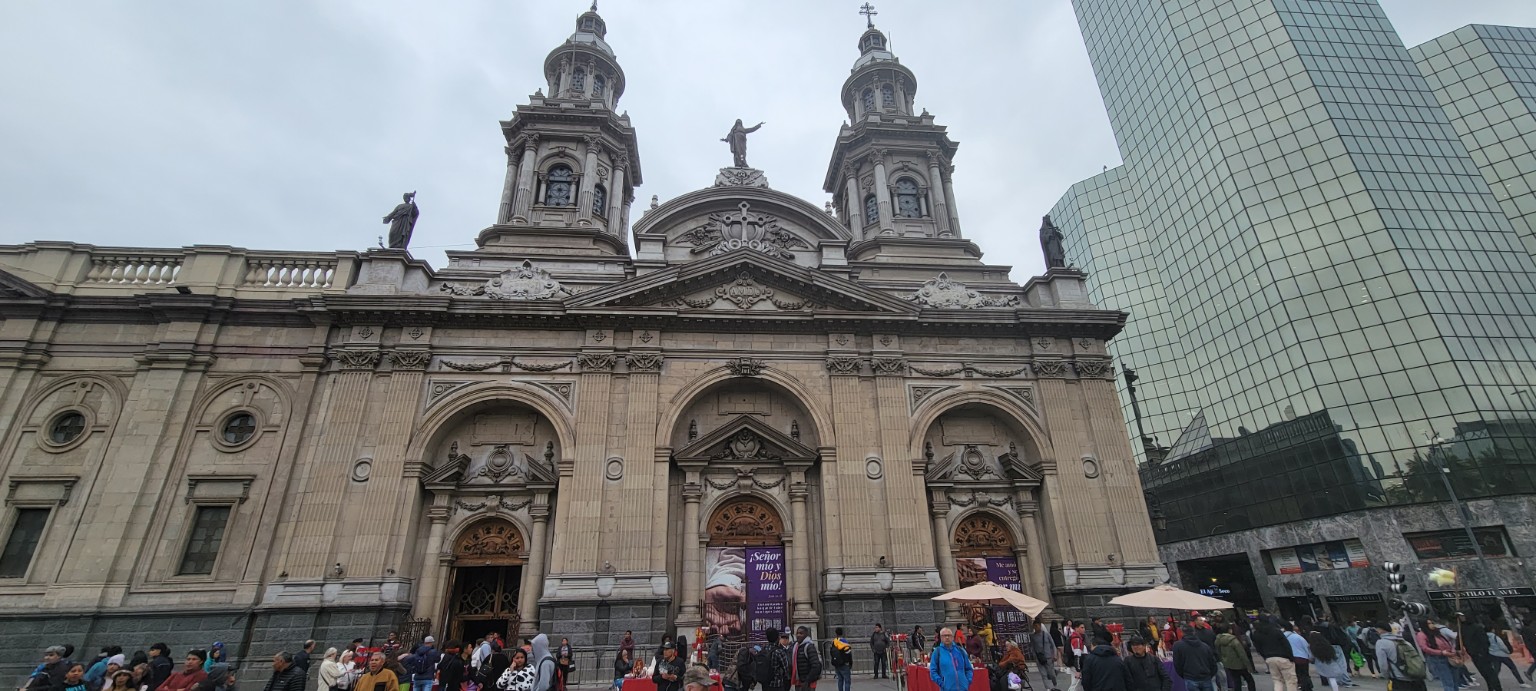 Wide view of the Metropolitan Cathedral of Santiago beside a modern glass building